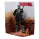Estátua de Deadpool em traje cinza com quadrinho e diorama.