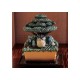 Estatua de Mi vecino Totoro bajo árbol con detalles mágicos