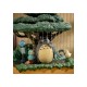 Estatua de Mi vecino Totoro bajo árbol con detalles mágicos