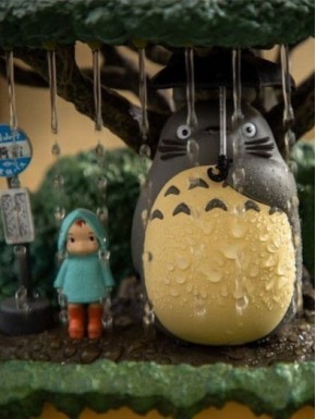 Estatua de Mi vecino Totoro bajo árbol con detalles mágicos