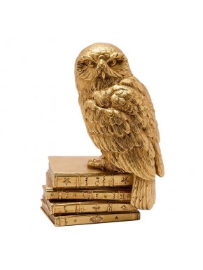 Figurine dorée de Hedwig sur livres
