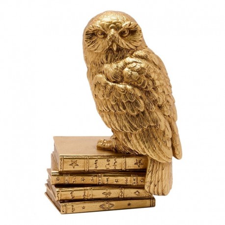 Figurine dorée de Hedwig sur livres